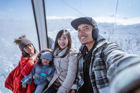 potrait of a family riding a cable car in the beautiful snowy mountain in turkeyの写真素材