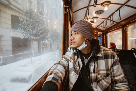 Portrait of young asian man looking through train window. man passenger riding classic train during...