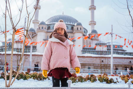 portrait of a girl looking at the camera with mosque in the backgroundの写真素材