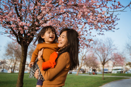 beautiful mother and daughter enjoy in the park during cherry blossom festivalの写真素材