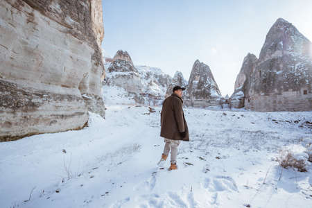 young asian man walking alone in beautiful snowy landscapeの写真素材
