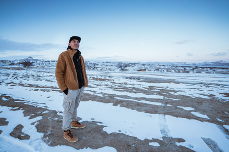 portrait of relaxed man enjoying the view of cappadocia cover with snow