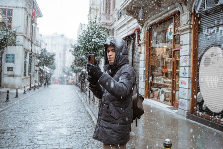 man taking picture with his smartphone while travelling to turkey during winter