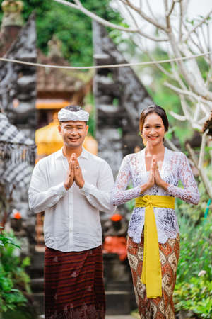 happy beautiful balinese couple greeting and smiling gesture at cameraの写真素材