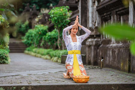 balinese woman do the prayer to god in the morning. hindu make an offering to their god using canangの写真素材