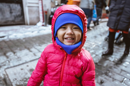 excited boy toddler wearing red hoodie in winter smiling to camera