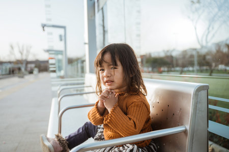 little girl waiting in station hoping the train to come as soon as possible
