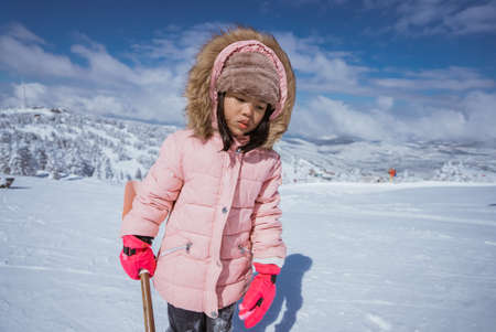 happy little girl playing outside in the snow with clear skyの写真素材