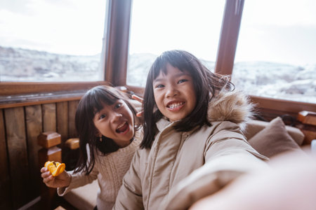happy two little girl taking self portrait using smartphone