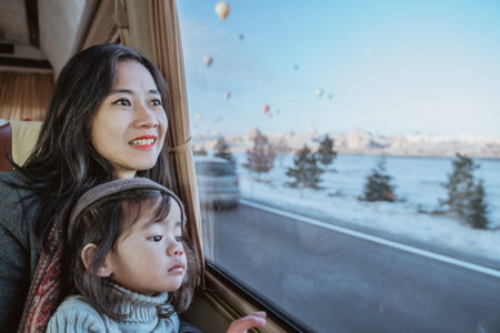 mother and daughter looking outside of a car window to a beautiful view of cappadocia fill with hot...