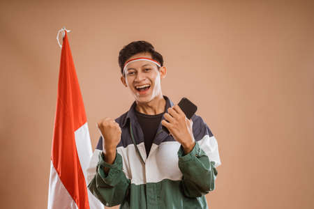 happy young male athelete using mobile phone over isolated backgroundの写真素材