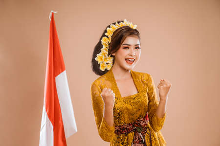 excited woman with balinese traditional kebaya costume over isolated backgroundの写真素材