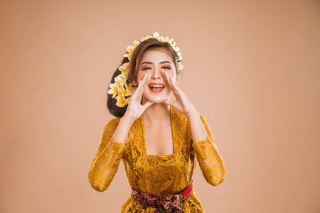 beautiful balinese woman with shouting gesture over isolated background