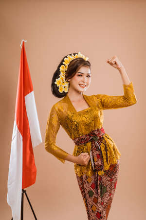 excited woman with balinese traditional kebaya costume over isolated backgroundの写真素材