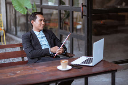 asian businessman thinking about business strategy while relaxing in coffee shopの写真素材