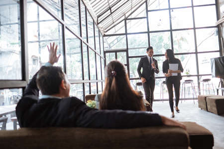 businessman and woman waving to their partner when meeting at a coffeeshopの写真素材