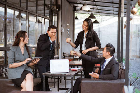 relaxed business worker enjoy drinking after finishing the meeting with partner in coffe shopの写真素材