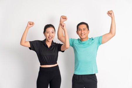 woman and man shouting with hands up clenched on isolated backgroundの写真素材