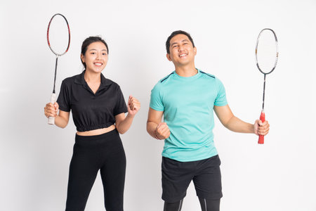 excited women and men standing holding rackets on isolated backgroundの写真素材