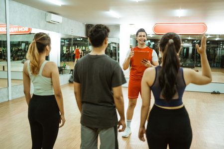 woman in sportswear asks by raising her hand during a briefing with an instructor before exercising