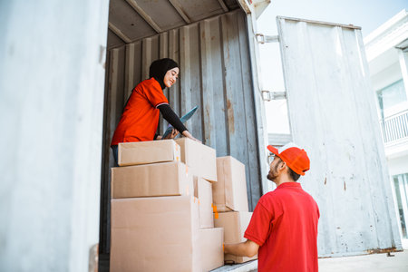 female worker in red uniform checks the package to be delivered by the delivery man to the customer