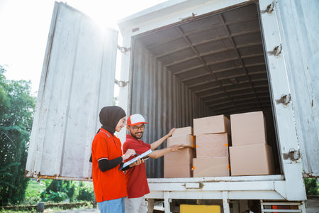 two forwarders checking boxes of delivery packages in a cargo vehicle