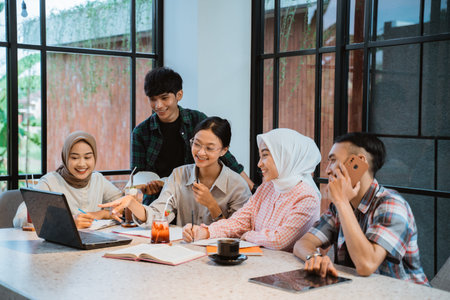 group of young Asian people chatting together in a cafe with glass windows in the background