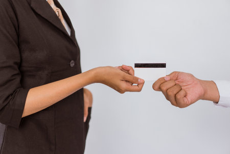 close up of the hand of the asian woman in formal outfit giving the blank card on isolated backgroundの写真素材