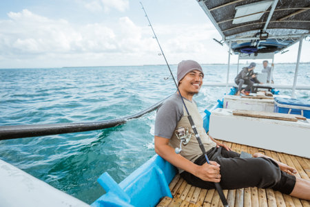 fisherman break fishing sitting on a small fishing boat at seaの写真素材