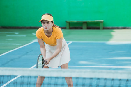 Asian female tennis player concentrating in a position ready to hold the racket on the tennis courtの写真素材