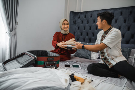 beautiful wife in veil prepares clothes for her husband while preparing a suitcase in the bedroom