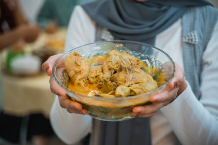 Muslim womens hands bring iftar dishes at home with familyの写真素材