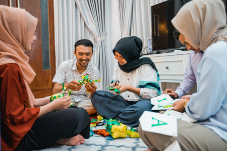 Muslim couple making ornamental ketupat weaving with friends for Eid celebration at homeの写真素材