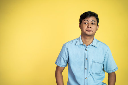 young Asian stand with cynical face with copyspace on isolated backgroundの写真素材