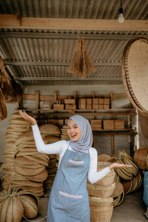 happy excited young muslim woman standing in front of her workshopの写真素材