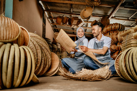 happy asian handicraft artist are working on their woven bamboo product in the shopの写真素材