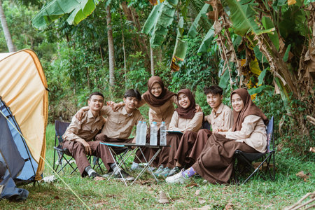 group of young scouts smiling at the camera while gathering in natureの写真素材