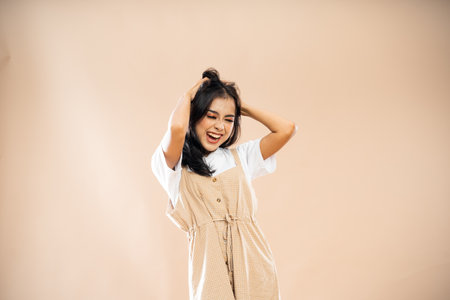 stress asian woman in casual clothes standing scrambling her hair on isolated backgroundの写真素材