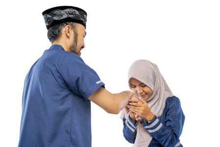 portrait of happy muslim daughter shake hand her father apologizing during eid mubarak over white backgroundの写真素材