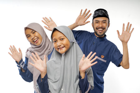 beautiful asian family with daughter wearing traditional islamic clothes over white backgroundの写真素材