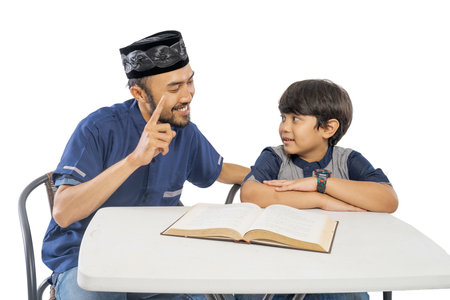 happy asian father and son read quran together over white backgroundの写真素材