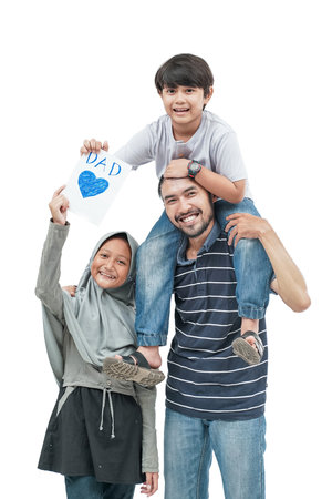 portrait of happy dad carry his son on a shoulder holding a love card for fathers dayの写真素材