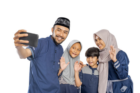 happy muslim family wave to their phone while making a video call and selfieの写真素材