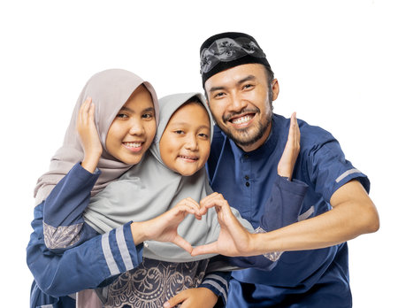 beautiful asian family with daughter wearing traditional islamic clothes over white backgroundの写真素材