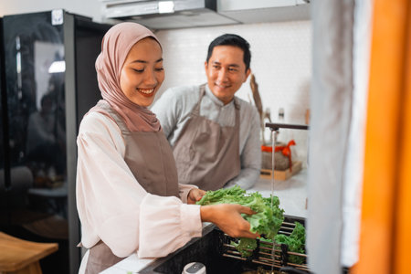 happy young muslim couple making food together at homeの写真素材