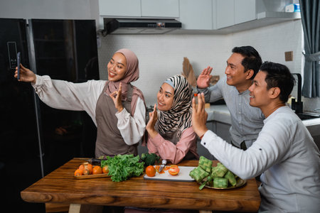 three friend with hijab looking at the phone searching for new recipe for dinnerの写真素材