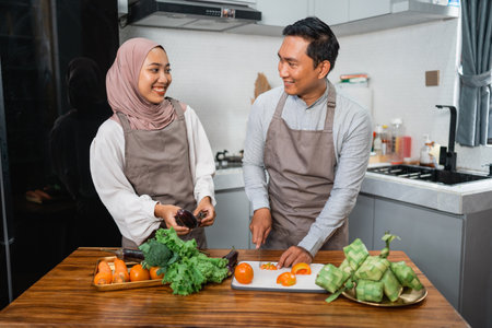 happy young muslim couple making food together at homeの写真素材