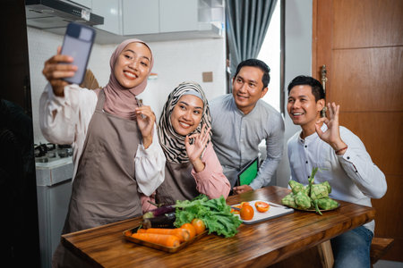 three friend with hijab looking at the phone searching for new recipe for dinnerの写真素材