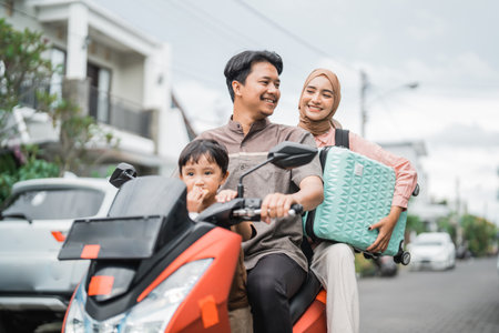 asian muslim family riding motorbike scooter together traveling with kid. eid mubarak travel conceptの写真素材