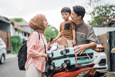 asian muslim family riding motorbike scooter together traveling with kid. eid mubarak travel conceptの写真素材